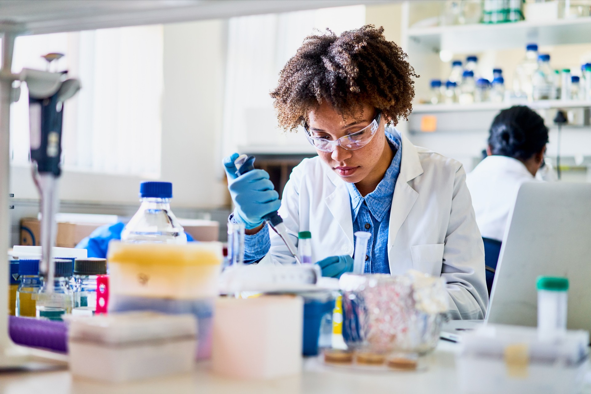 Young scientist using a pipette to analyzing a sample in a lab