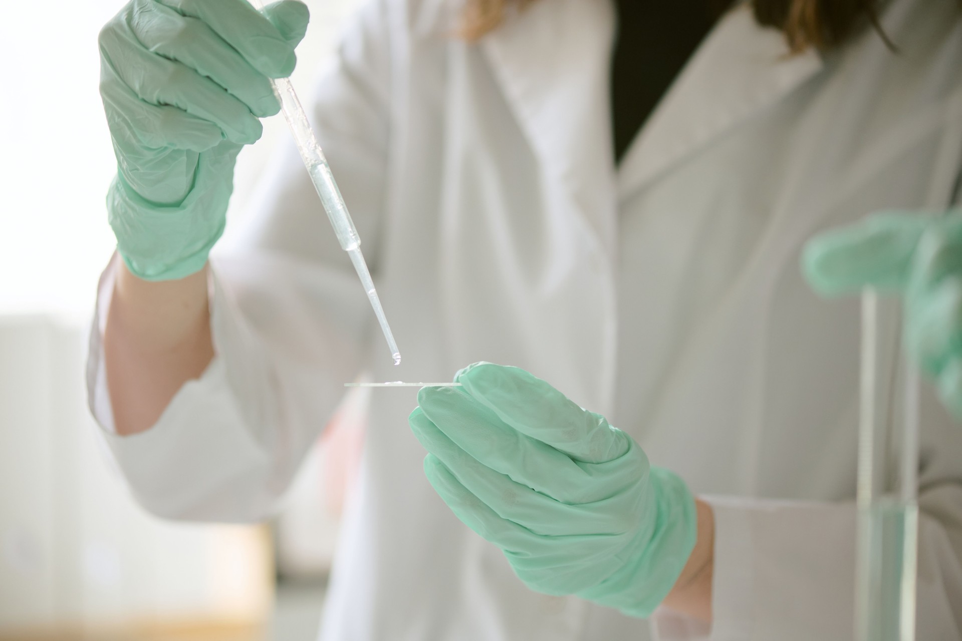 Gloved Hands Holding Laboratory Pipette for Experiment
